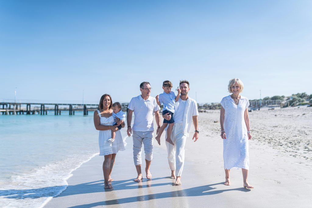 Happy multi-generational family enjoying a beach day together under the summer sun.